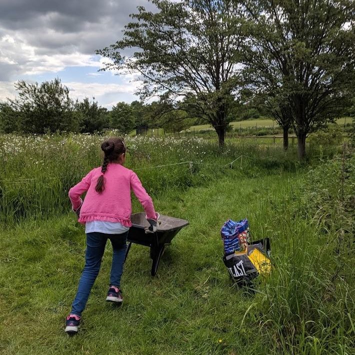 GIV MK volunteer racing around with a wheel-barrow