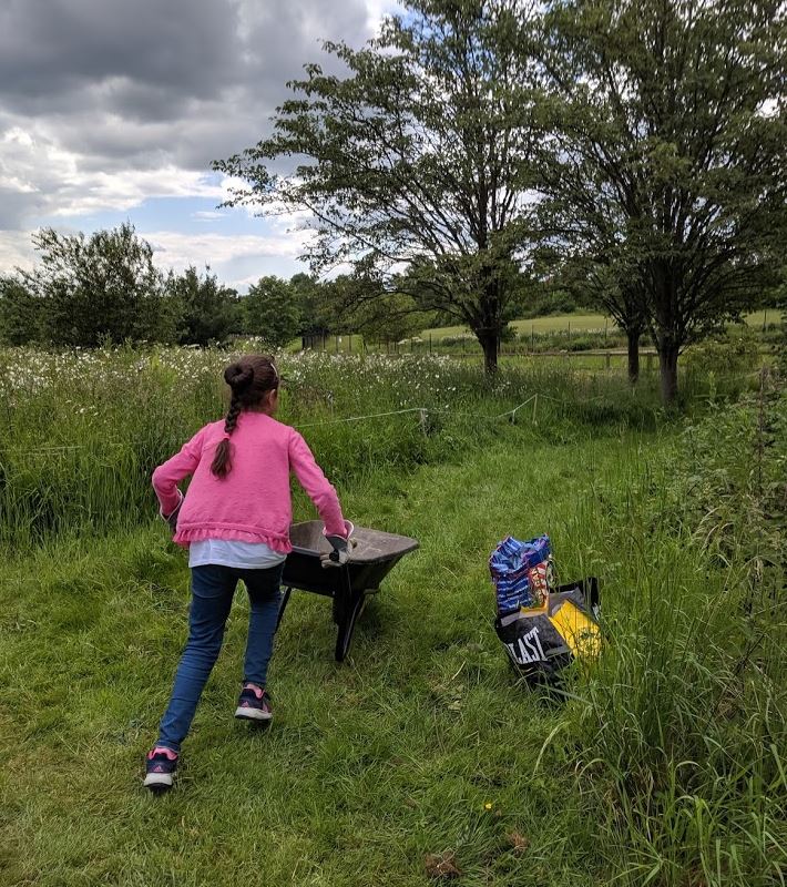 GIV MK volunteer racing around with a wheel-barrow