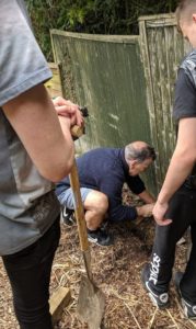 GIV MK volunteers prepare the fence for painting