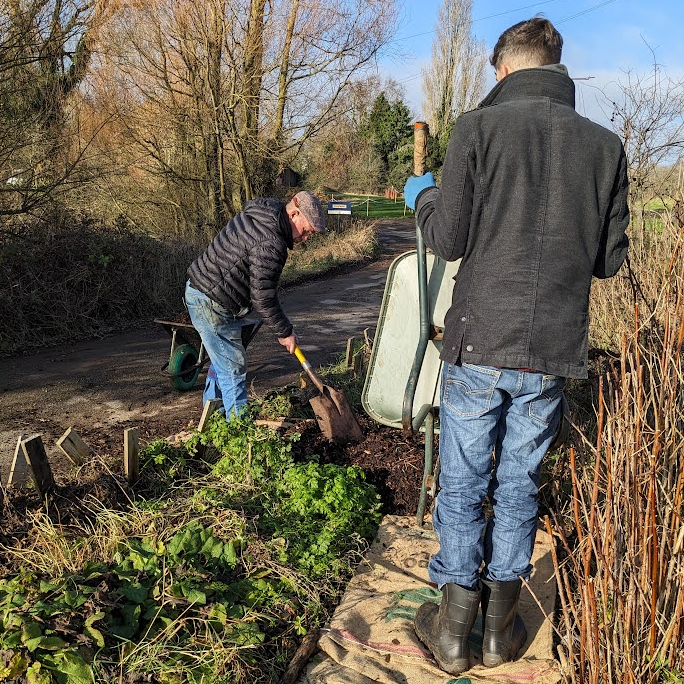 Adding woodchip on top of the Hessian sacks lining our garden path